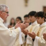 Biskup udzielający sakramentu bierzmowania młodym ludziom w kościele